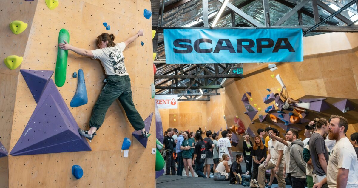 ボルダリングコンペティションで登る女性クライマーと観客