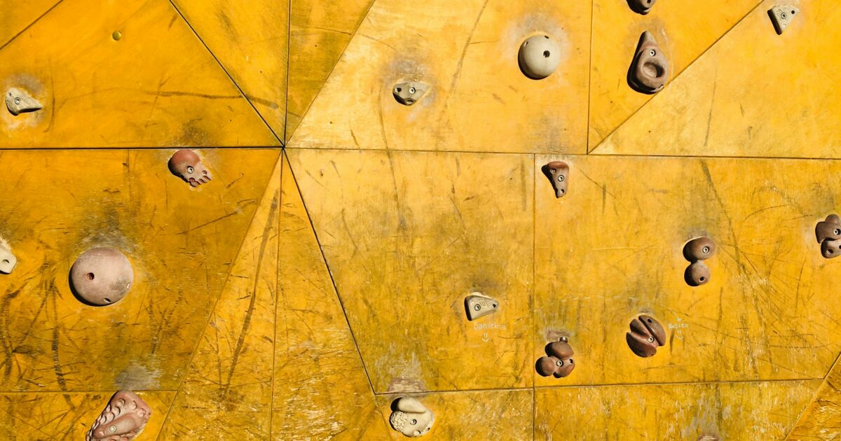 黄色いパネルに多数のホールドが取り付けられたクライミングウォール