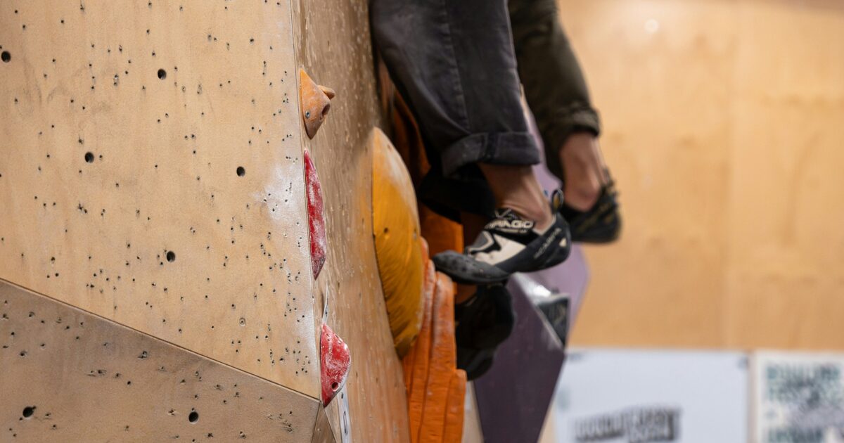 クライミングシューズでホールドに立つクライマーの足元のクローズアップ