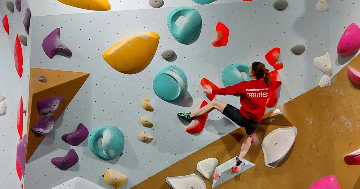 ボルダリングジムで多彩なホールドに挑戦する女性クライマー